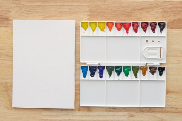 Set di colori ad acquerello con carta bianca. Vernici aquarelle multicolori luminose per sfondo artistico.