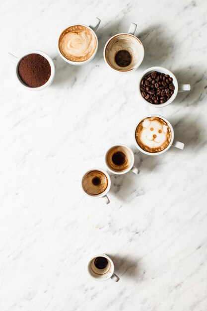 Set di diverse tazze da caffè come punto interrogativo, vista dall'alto, vista dall'alto. Filosofia del concetto di vita