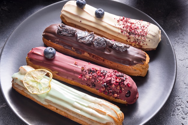 Set di diverse torte eclair su backgrouns scuri