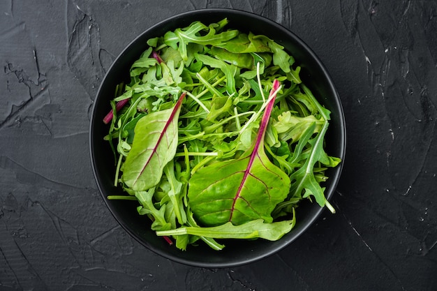 set di foglie di insalata mista, bietola e rucola, su pietra nera