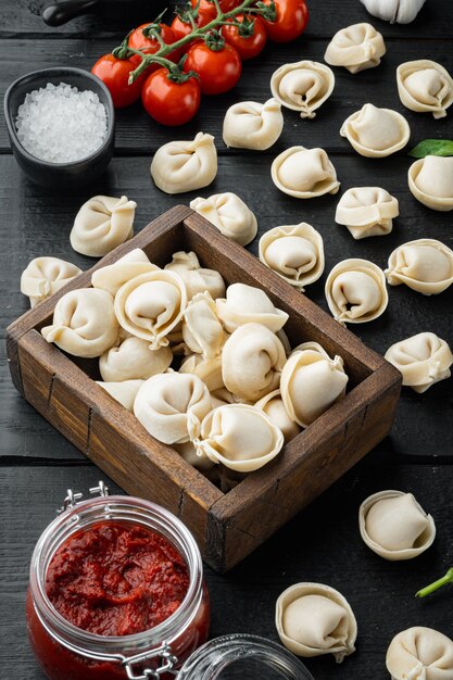 Set di ingredienti tortellini, sul fondo della tavola in legno nero