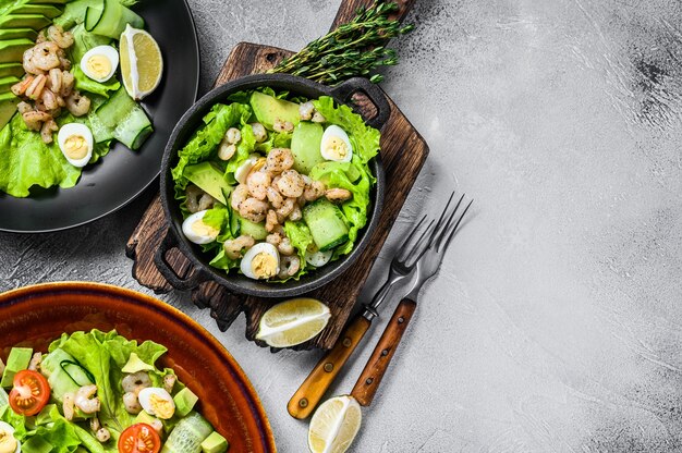 Set di insalate con avocado, gamberi, gamberi e verdure in ciotole