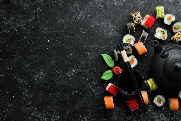 Set di involtini di sushi con wasabi allo zenzero e salsa di soia su sfondo di pietra nera Cucina tradizionale giapponese Vista dall'alto Stile rustico