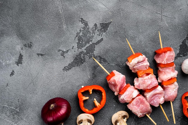 Set di kebab crudo, vista dall'alto piatta, con spazio di copia per il testo, su sfondo di tavolo in pietra grigia