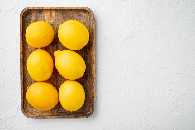 Set di limoni freschi, sul vassoio in legno, su sfondo bianco, vista dall'alto laici piatta, con copyspace e spazio per il testo