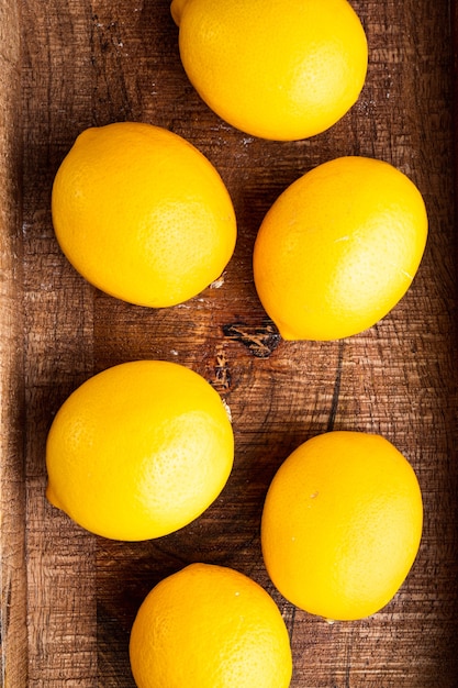 Set di limoni maturi, in una scatola di legno, su sfondo grigio, vista dall'alto laici piatta