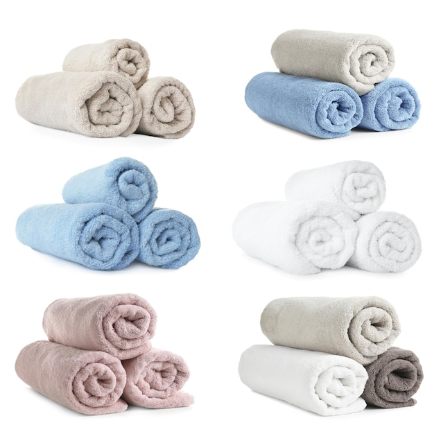 Set di morbidi asciugamani in spugna arrotolati su sfondo bianco