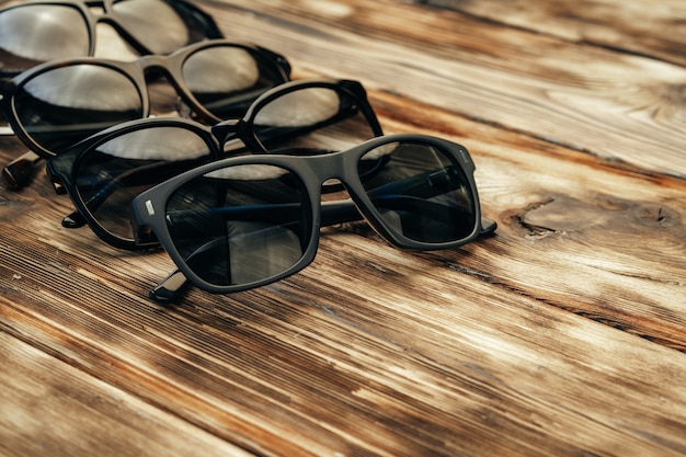 Set di occhiali da sole scuri sulla superficie di legno marrone del grunge