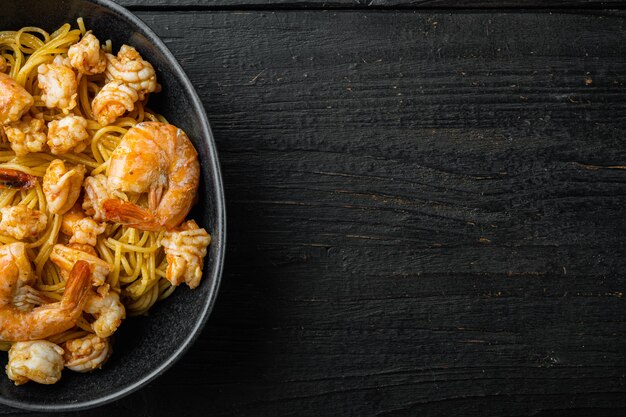 Set di pasta di gamberi al pesto di rose, in una ciotola, su legno nero