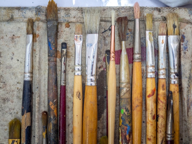Set di pennelli per artisti Disposizione piatta di molti strumenti per artisti nel supporto per pennelli in calicò