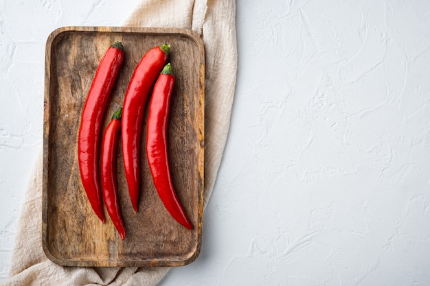 Set di peperoncino rosso crudo, su sfondo bianco con texture, laici piatta con spazio per il testo