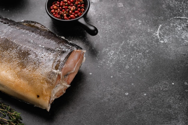 Set di pesce trota intero affumicato, su sfondo nero tavolo in pietra scura, con spazio copia per il testo