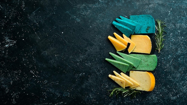 Set di pezzi di formaggio colorato con noci, lavanda, basilico e parmigiano su sfondo scuro Spazio libero per la copia Vista dall'alto