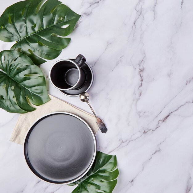 Set di piatti alla moda moderni e tazza di caffè su marmo.