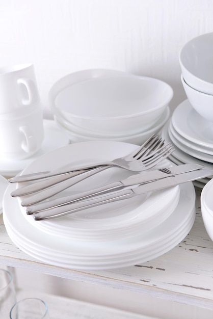 Set di piatti bianchi sul tavolo su sfondo chiaro