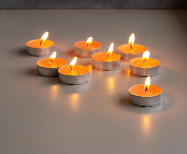 Set di piccole candele accese arancioni sul tavolo