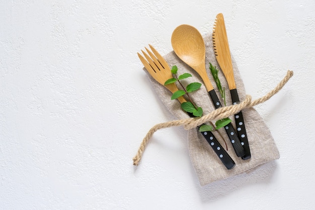 Set di posate in bambù e tovagliolo su sfondo bianco. Regolazione naturale della tavola