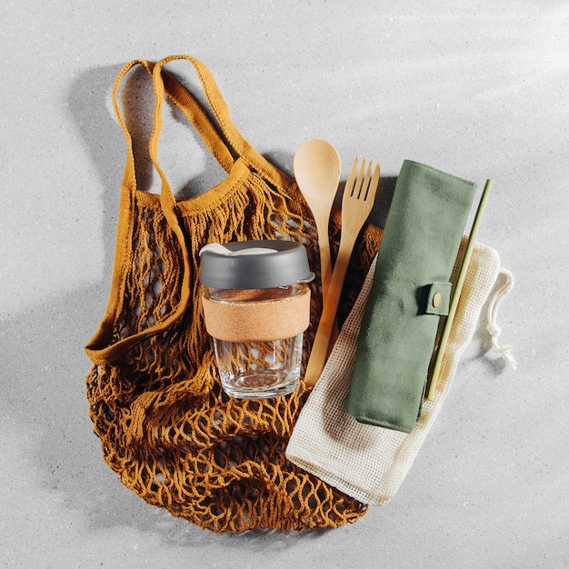 Set di posate in bambù ecologico, borsa ecologica e tazza da caffè riutilizzabile. Stile di vita sostenibile. Concetto senza plastica.
