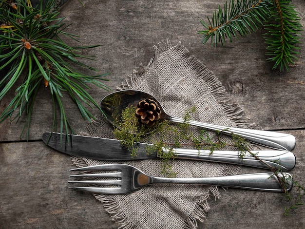 Set di posate rustiche d'epoca con tovagliolo in stile country e cono di brunch in abete con decorazione natalizia su sfondo di legno Vista dall'alto dello spazio di copia