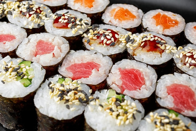 Set di rotoli di sushi in assortimento su uno sfondo nero