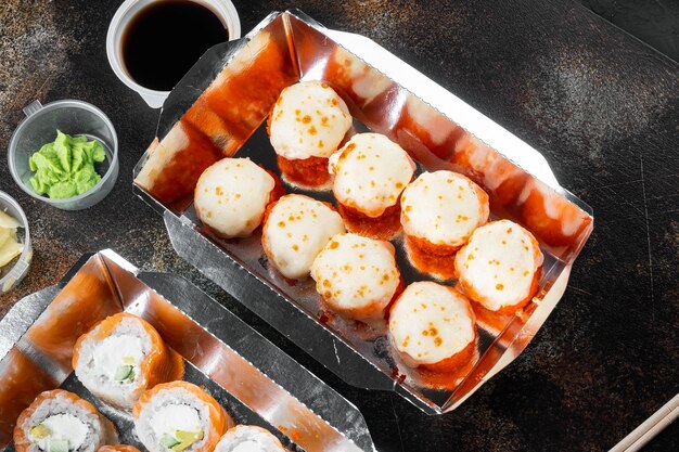 Set di rotoli di sushi in scatola di cibo di consegna su vecchio sfondo rustico scuro