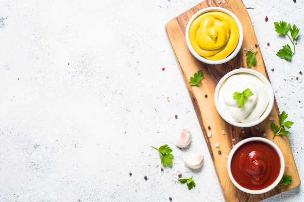 Set di salse ketchup, maionese e senape su sfondo bianco Vista dall'alto