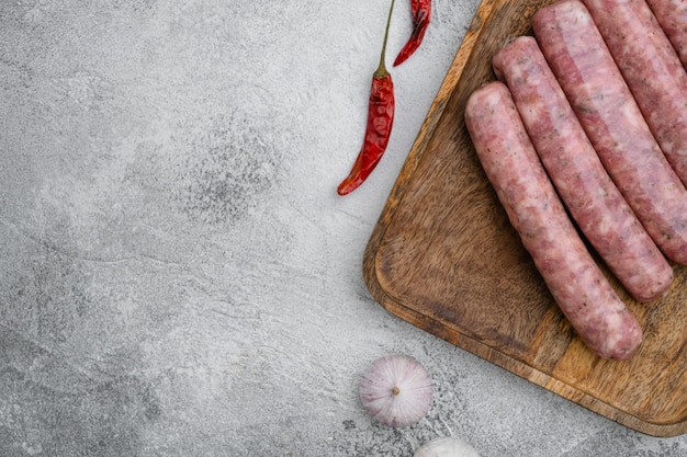 Set di salsicce fresche fatte in casa, su sfondo di tavolo in pietra grigia, vista dall'alto piatta, con spazio di copia per il testo