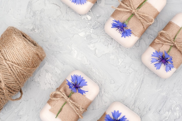 Set di sapone naturale fatto a mano decorato con carta artigianale, flagello e fiori blu.