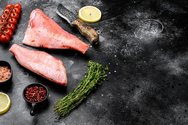 Set di snapper crudo di pesce, su sfondo di tavolo in pietra nera scura, con spazio di copia per il testo