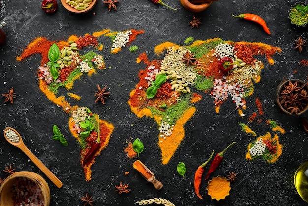 Set di spezie ed erbe aromatiche Cucina indiana Mappa del mondo Pepe sale paprika basilico curcuma Su una tavola di legno nera Vista dall'alto Spazio libero per la copia