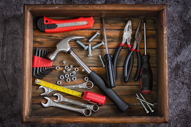 Set di strumenti per la riparazione domestica Le pinze per martello chiodi dadi giacciono in una scatola di legno Strumenti per la costruzione domestica