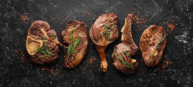 Set di succose bistecche alla griglia e carne Vista dall'alto Vista dall'alto piatto su un tavolo da taglio in pietra nera