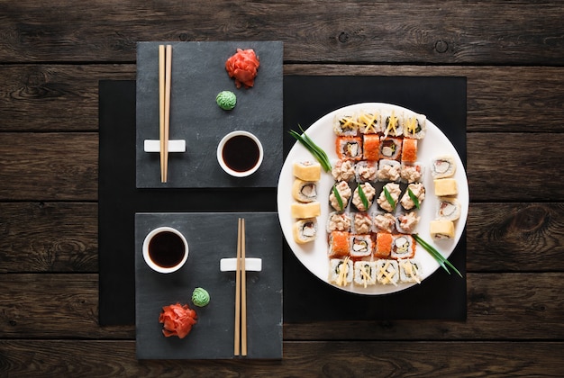 Set di sushi maki e rotoli su legno rustico nero