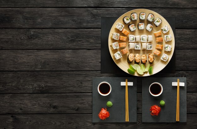 Set di sushi maki e rotoli su legno rustico nero