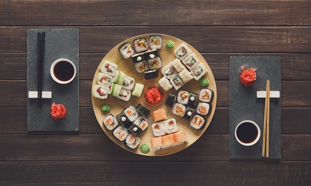 Set di sushi maki e rotoli su legno rustico nero