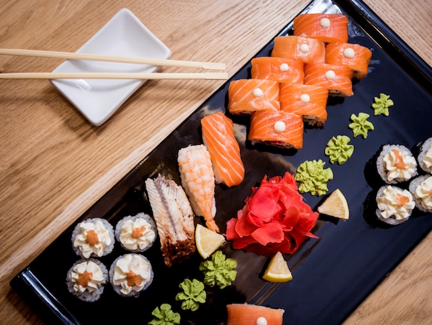 Set di sushi Rotoli con salmone, anguilla e caviale rosso su un piatto di legno. Ristorante.