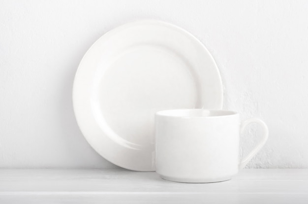 Set di tazza e piatto su sfondo bianco