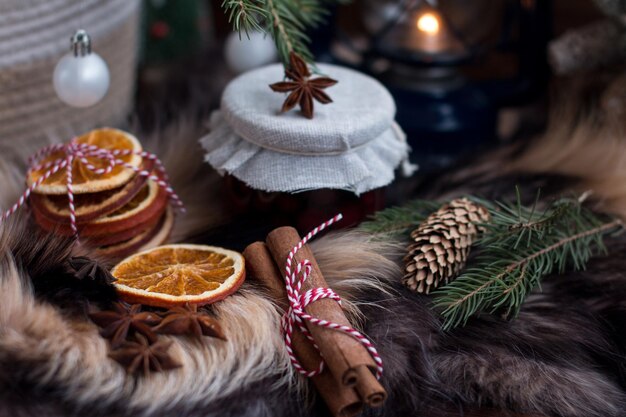 set di tè fette di arance secche per vino bollito bastoncini di cannella e anice a stella inverno freddo nel villaggio marmellata di ciliegio sullo sfondo di una lanterna in fiamme e pelliccia di volpe naturale