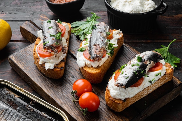 Set di toast con sardine di ricotta, su sfondo di tavolo in legno scuro vecchio