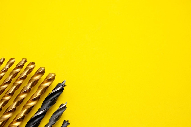 Set di trapani per legno e metallo su sfondo giallo.