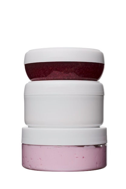 Set di tre vasetti cosmetici in plastica rosa rossa bianca per crema viso su sfondo bianco isolato