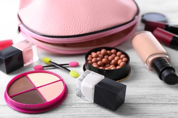 Set di trucco con estetista e cosmetici su sfondo bianco di legno