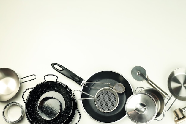 Set di utensili da cucina diversi su sfondo bianco.