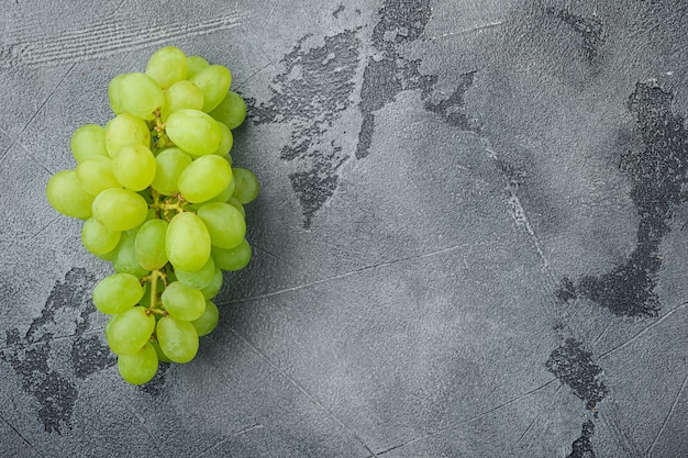 Set di uva succosa organica naturale, frutti verdi, sul tavolo di pietra grigia, vista dall'alto laici piatta