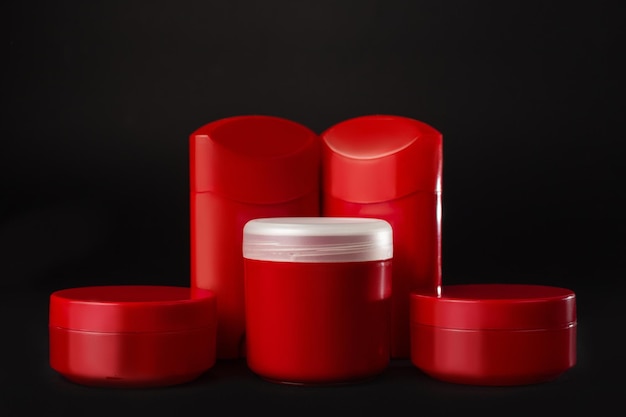 Set di vasetti cosmetici senza etichetta Confezione cosmetica mockup di branding vaso rosso vuoto isolato su sfondo nero