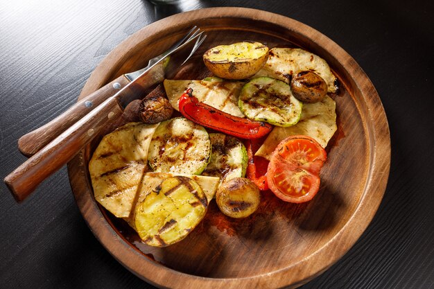 Set di verdure al forno zucchine pomodoro patate peperone su piatto di legno