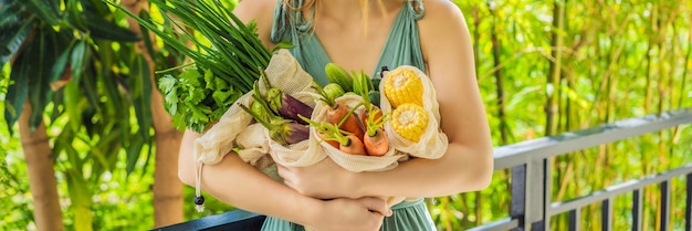 Set di verdure fresche in una borsa riutilizzabile nelle mani di una giovane donna zero concept banner