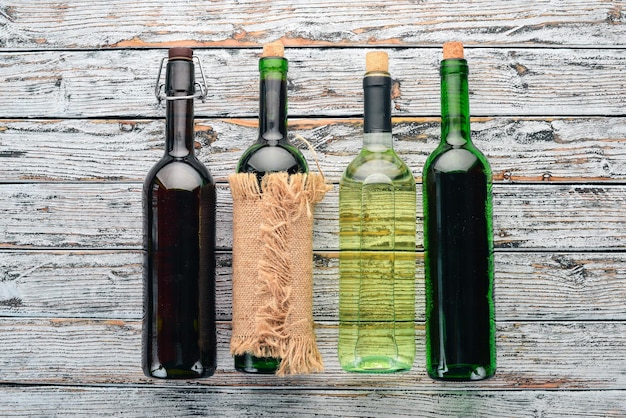 Set di vino rosso e bianco in bottiglie e bicchieri Uva su fondo di legno bianco Spazio libero per il testo Vista dall'alto