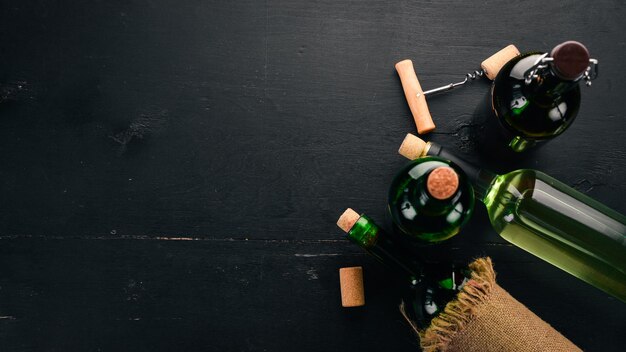 Set di vino rosso e bianco in bottiglie e bicchieri Uva su fondo di legno nero Spazio libero per il testo Vista dall'alto