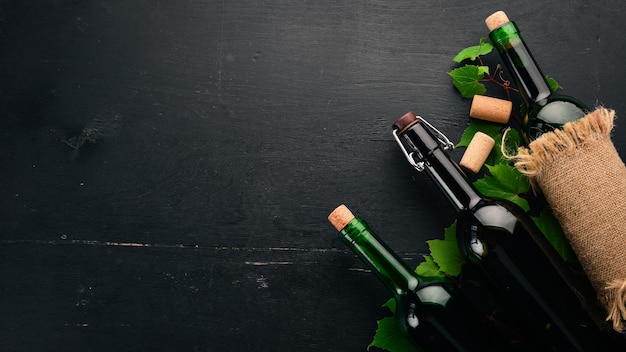 Set di vino rosso e bianco in bottiglie e bicchieri Uva su fondo di legno nero Spazio libero per il testo Vista dall'alto